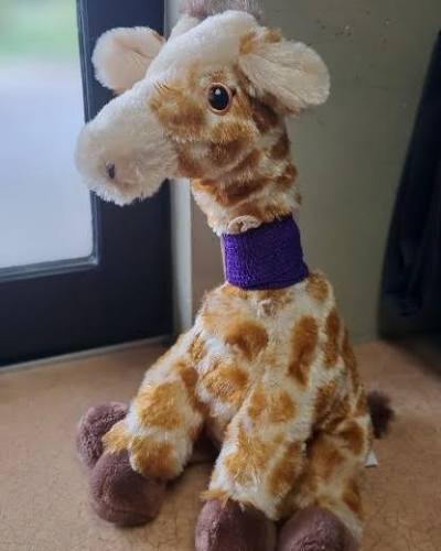 A giraffe plush with a purple neck wrap, supplied as a community reference.